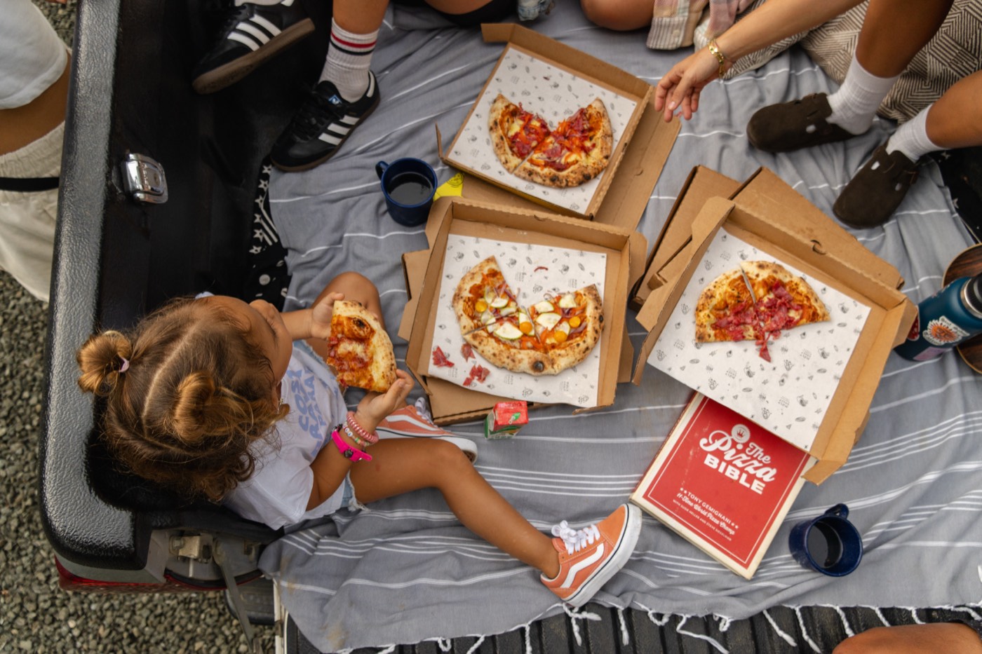 Holy Crust pizza boxes at an outdoor picnic event