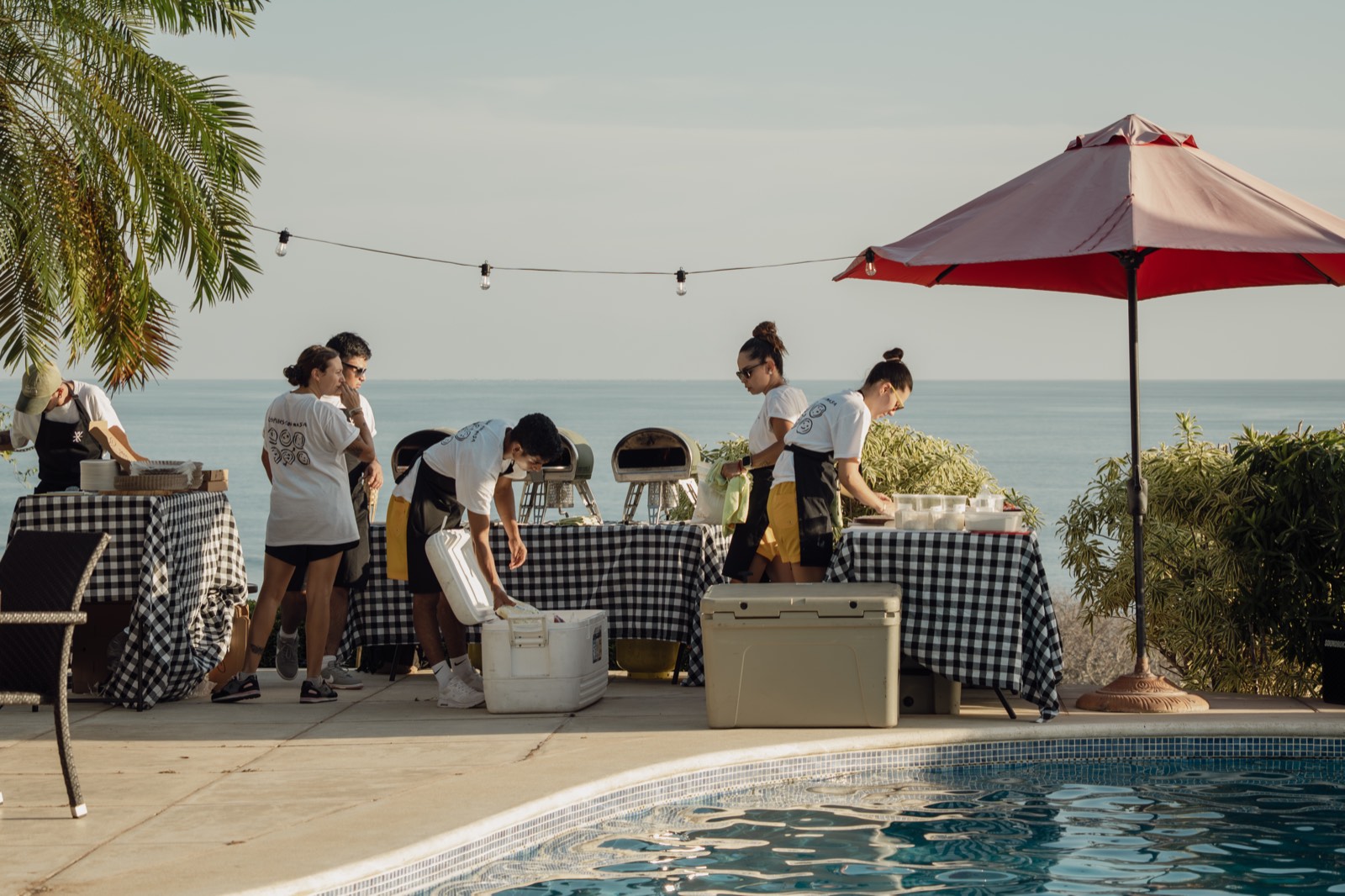 Holy Crust poolside catering setup at sunset