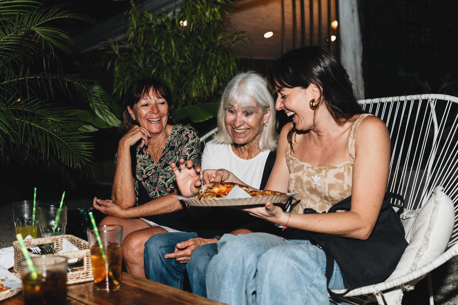 Guests holding plates of pizza at an evening Holy Crust event