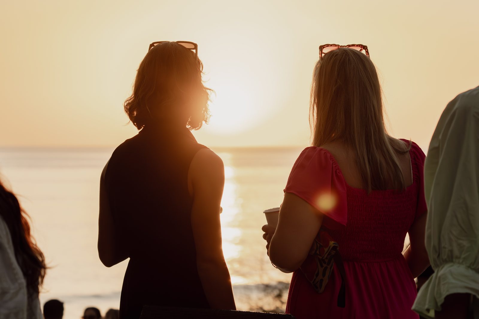 Two guests in silhouette against the sunset at a Holy Crust event