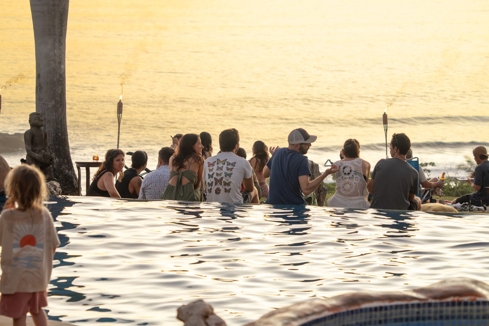 Guests at an infinity pool during a Holy Crust sunset event